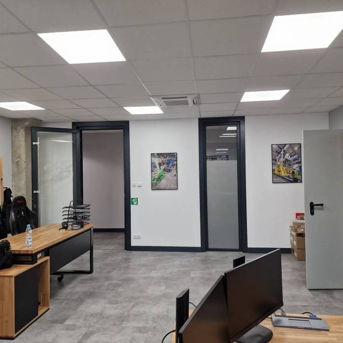 Nowoczesne biuro MS Industry z drewnianymi biurkami i stanowiskami komputerowymi. 