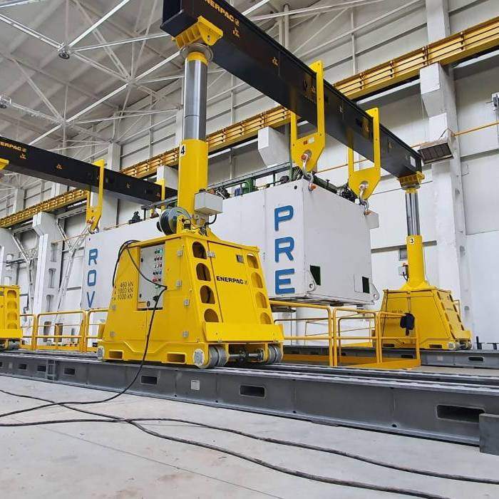 Podnoszenie korpusu prasy Rovetta 1000t na torach montazowych z wykorzystaniem silownikow hydraulicznych. 