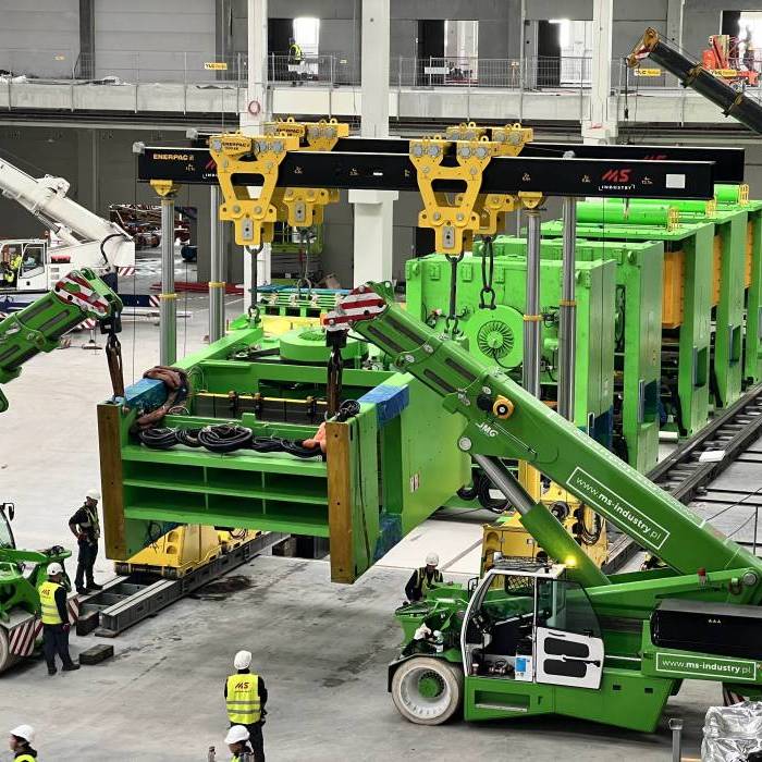 Ustawienie szesciu pras przemyslowych w linii produkcyjnej z wykorzystaniem systemu podnoszenia hydraulicznego. 