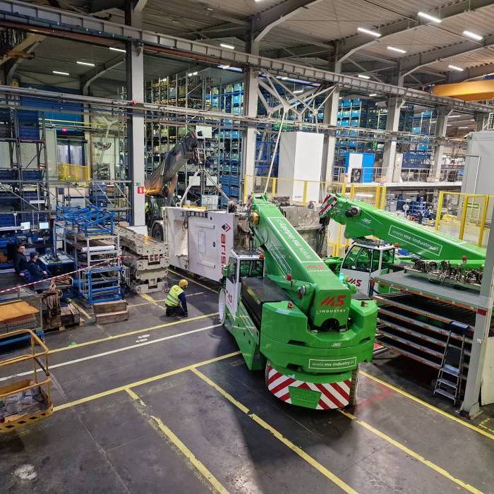 Transport prasy ARISA po hali przemyslowej z zabezpieczeniem strefy pracy. 