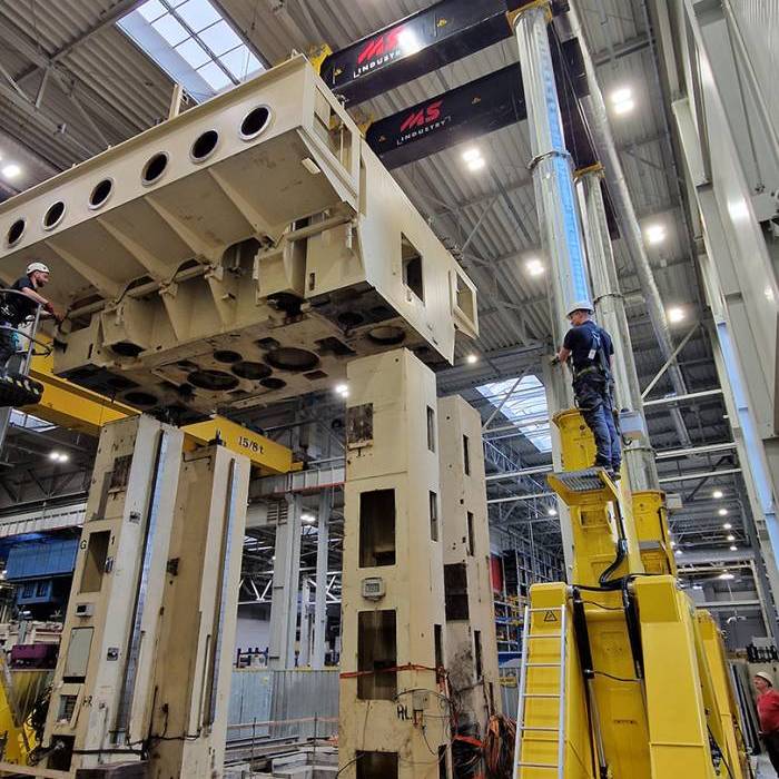 Podnoszenie konstrukcji prasy przy uzyciu zsynchronizowanych silownikow hydraulicznych. 