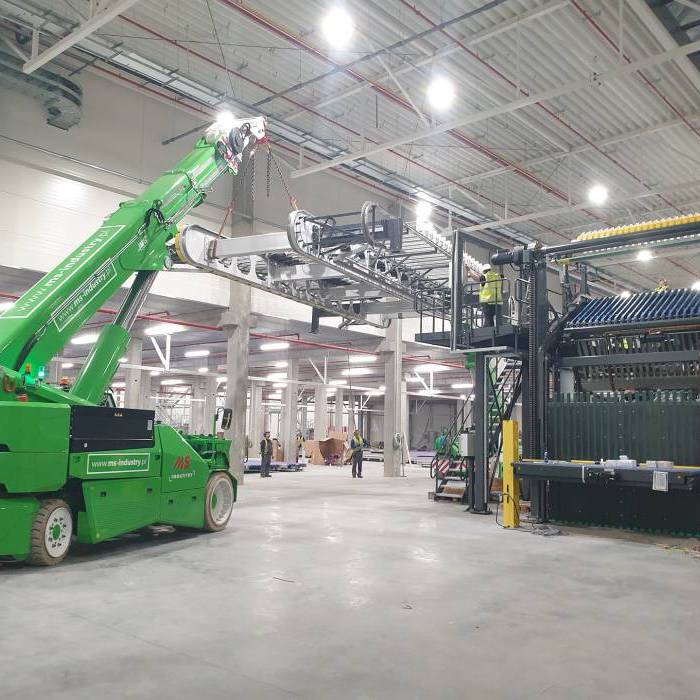 Montaz sekcji tekturnicy przy uzyciu zurawia elektrycznego JMG w hali produkcyjnej. 