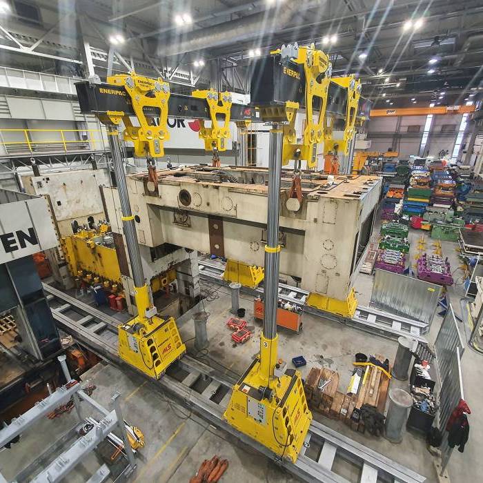 Podnoszenie ramy prasy Erfurt przy uzyciu slupow hydraulicznych i belek stalowych. 