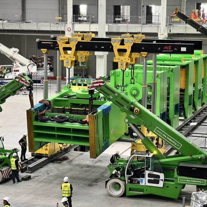 Ustawienie szesciu pras przemyslowych w linii produkcyjnej z wykorzystaniem systemu podnoszenia hydraulicznego. 