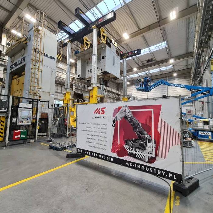Montaż prasy przemysłowej z zastosowaniem hydraulicznych systemów podnoszenia. 
